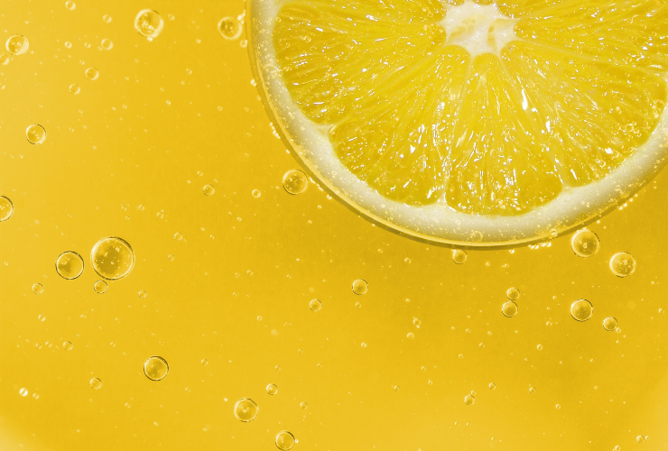 Picture with a yellow background with some bubbles and a lemon cut in half at the top right corner (only have the lemon shows)