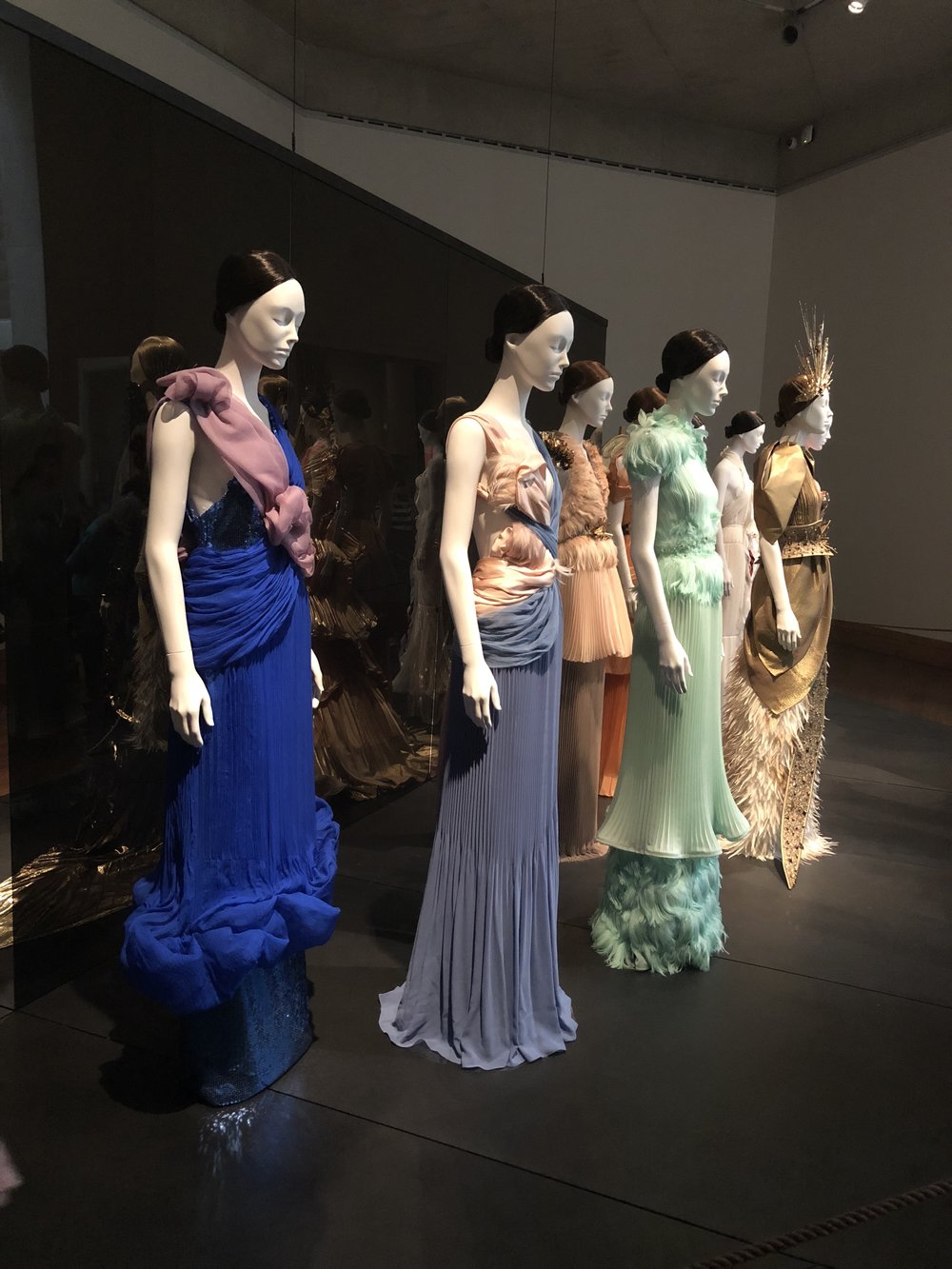 Lots of mannequins wearing dresses inside an exhibit at The Metropolitan Museum of Art