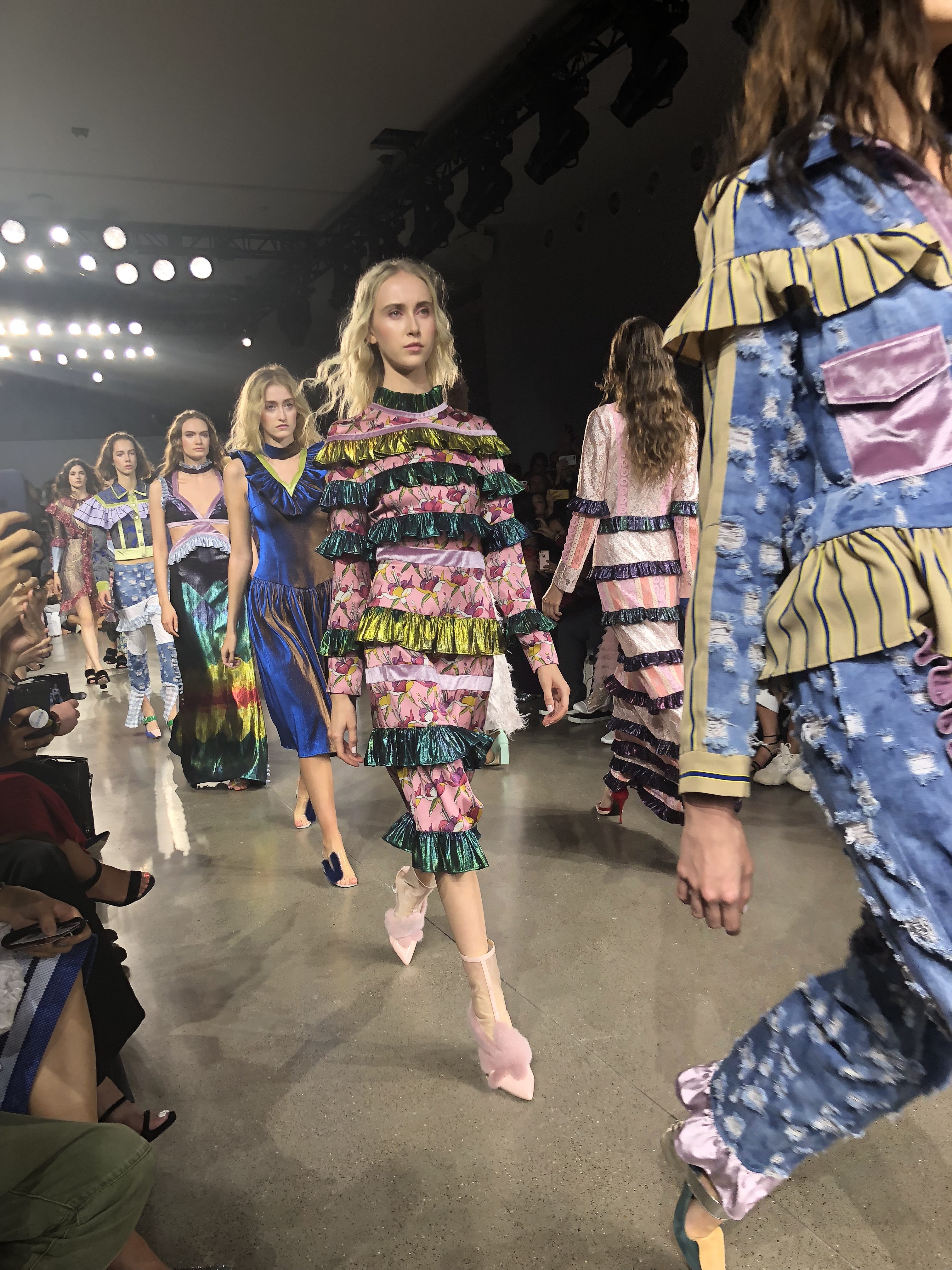 Models walking down a catwalk during new york fashion week