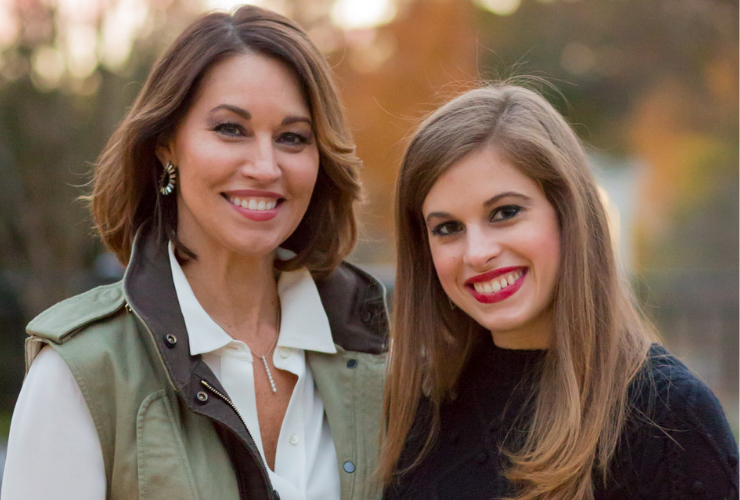 Two white women with brown hair smiling at the camera