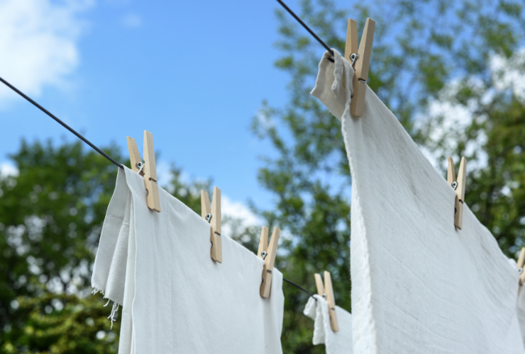 two white sheets hanging to dry on a clothes line
