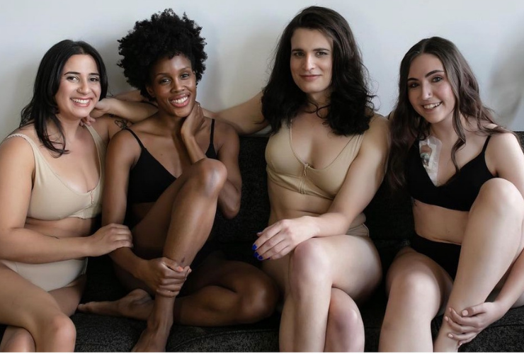 4 women some white & 1 black girl in bras and panties smiling at the camera