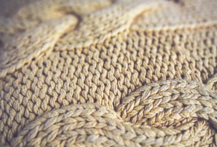 close up of a cream cable-knit sweater