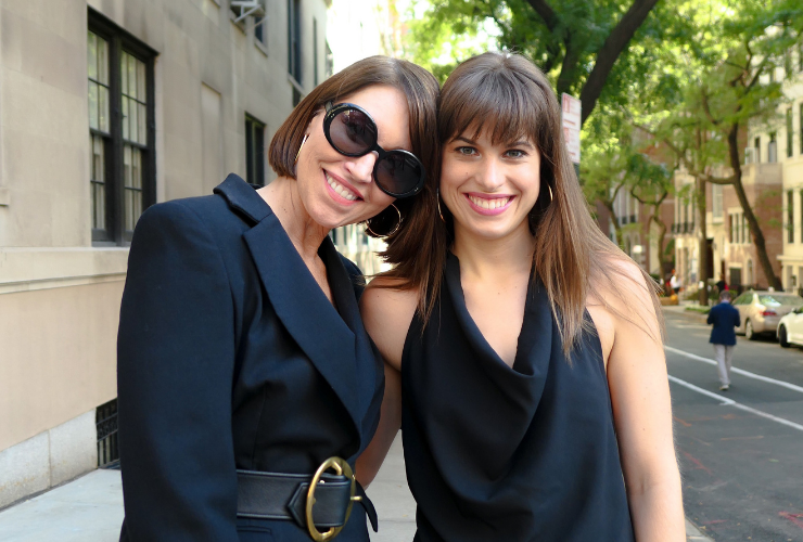 Two women wearing black looking at the camera & smiling