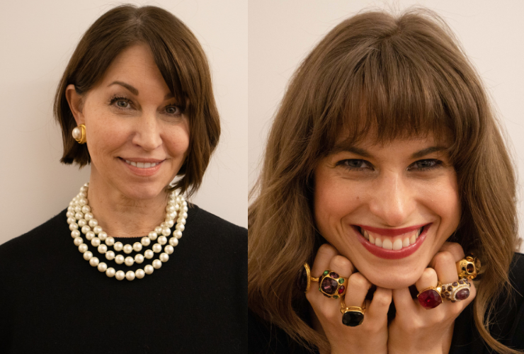 Two white women with brown hair staring at the camera & smiling wearing jewelry