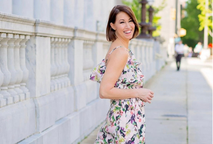 White woman with brown hair wearing a floral dress