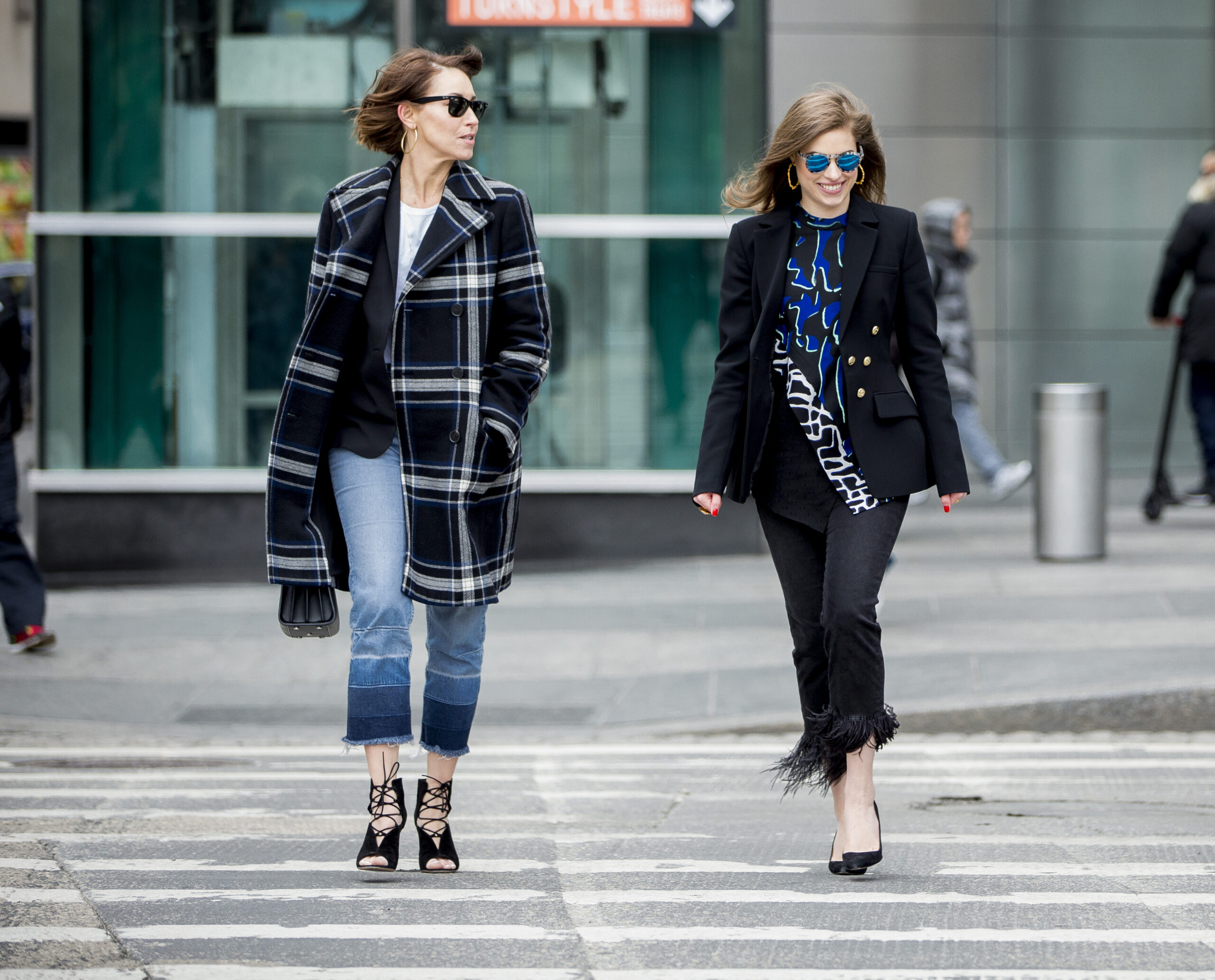 two white women with brown hair walking across a NYC crosswalk