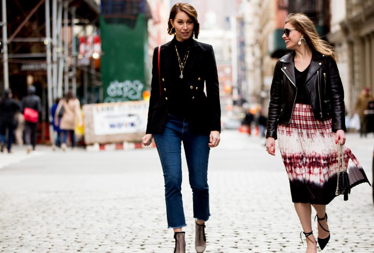 two white women with brown hair walking down a cobblestone street in Soho